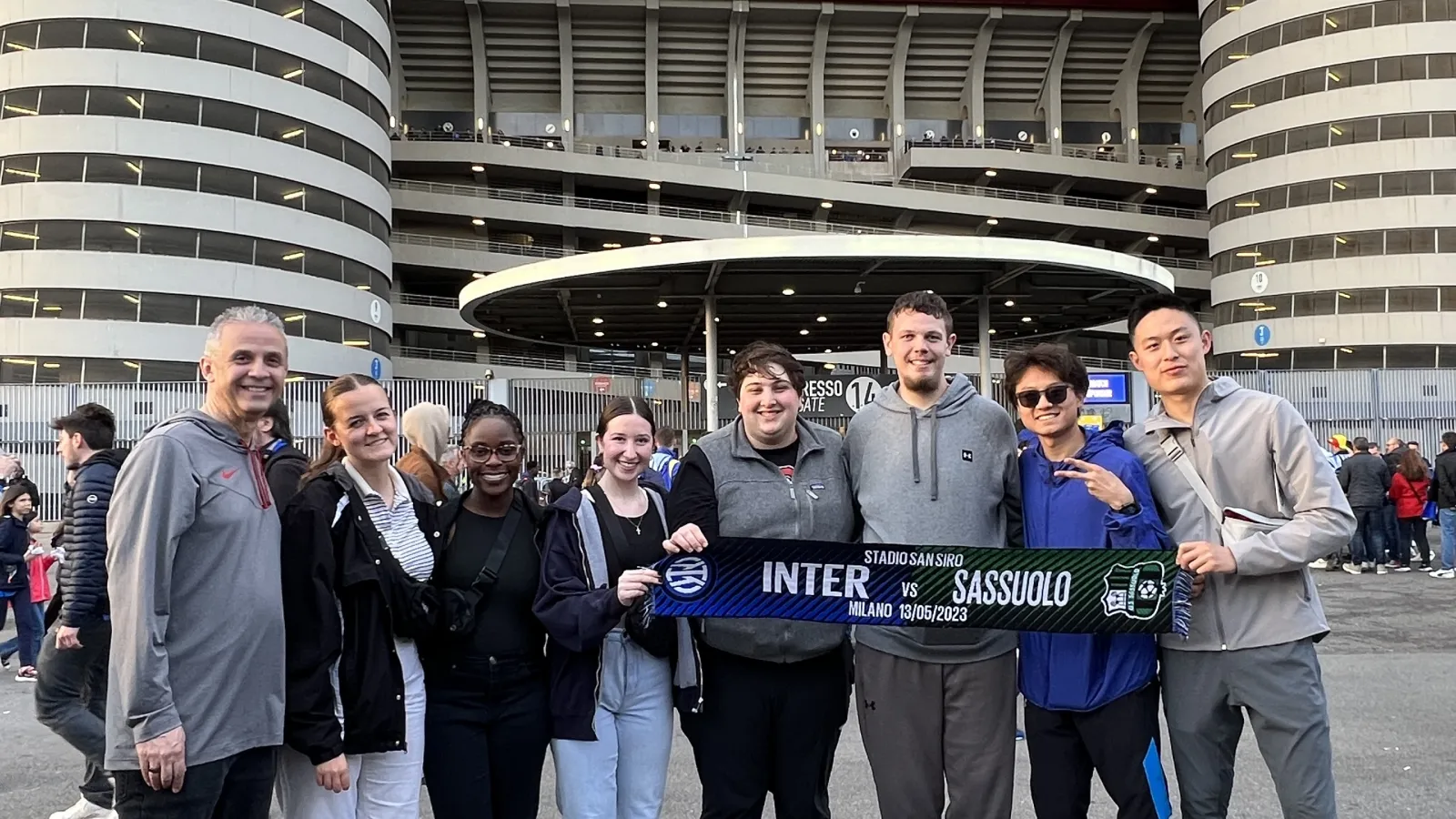 Students pose outside football stadium