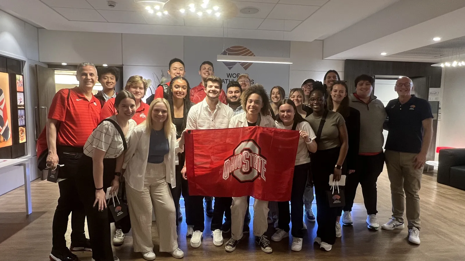 Students pose with flag at office