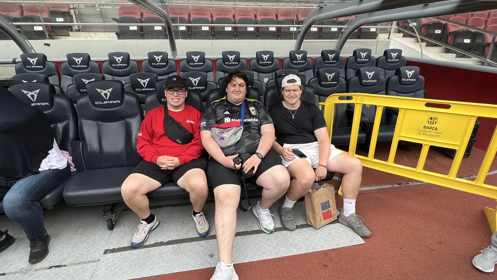 Students sit in chairs on soccer field