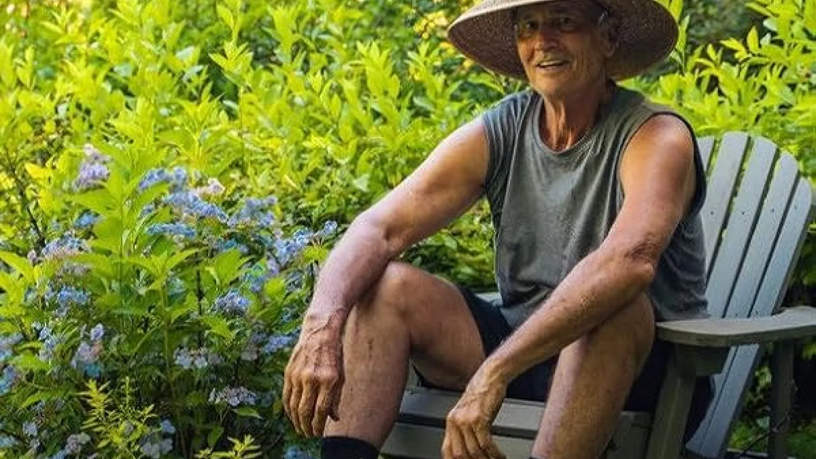 man sitting on chair in overgrown garden