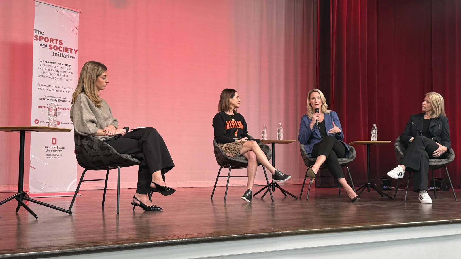Four women sitting on stage