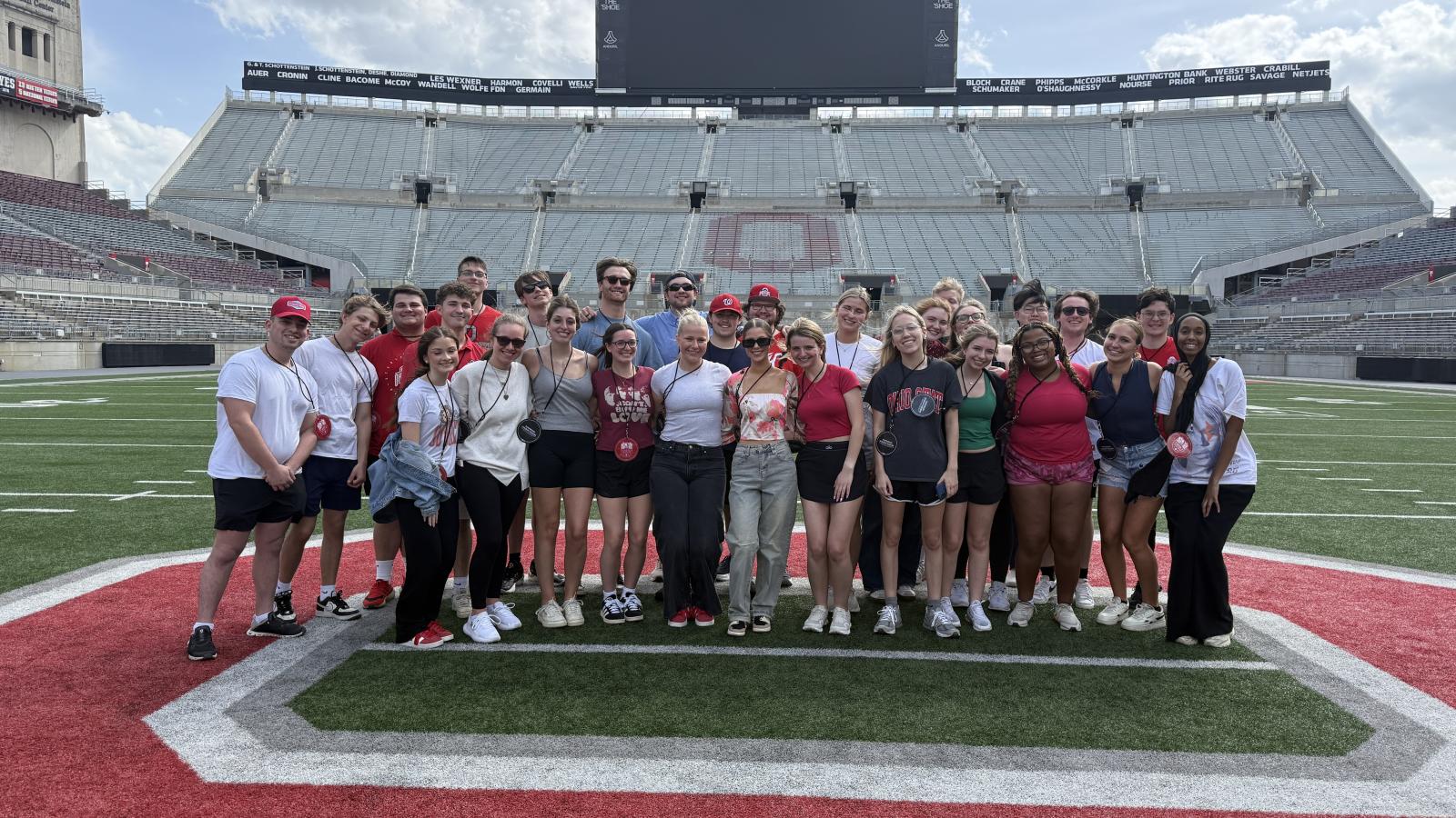 students posing at Ohio Stadium field