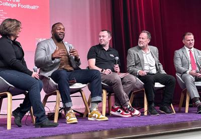 Five people talking on stage